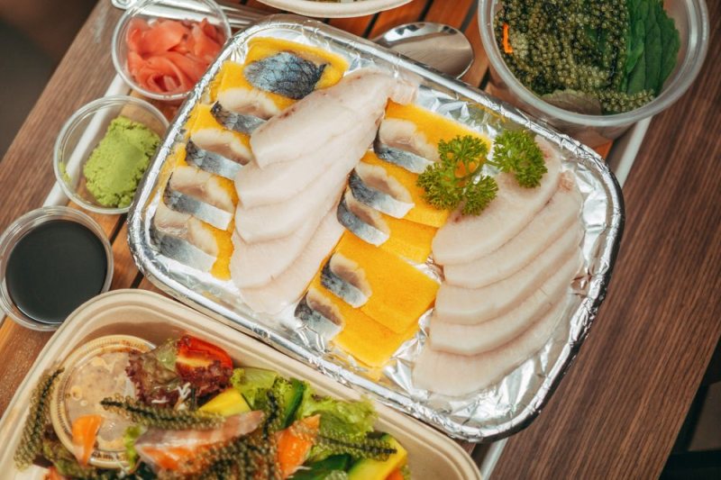 A platter of white fish sashimi with wasabi and ginger