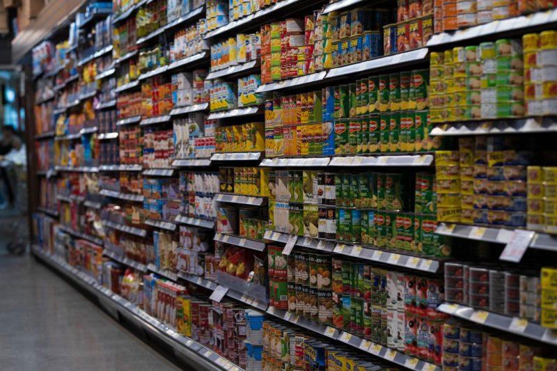 A supermarket aisle stocked with canned goods