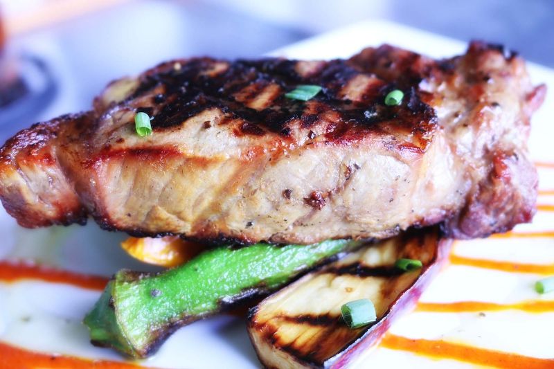 A grilled tuna steak served with vegetables